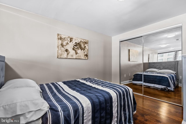 bedroom with a closet, baseboards, and wood finished floors