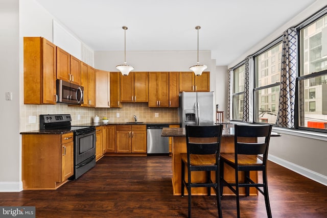 kitchen with a sink, stainless steel appliances, dark wood-type flooring, and tasteful backsplash