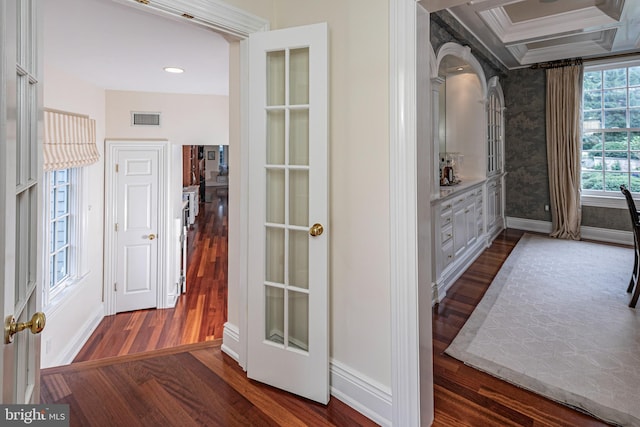 interior space with baseboards, visible vents, ornamental molding, dark wood-type flooring, and french doors