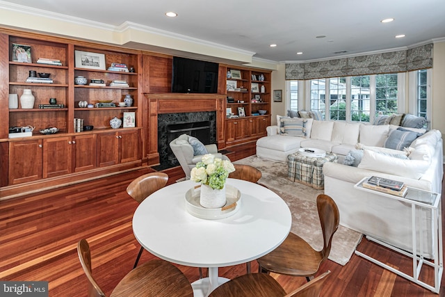 living room with dark wood-style floors, a premium fireplace, recessed lighting, and crown molding