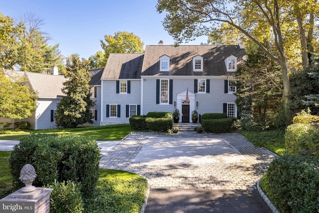 view of front of property featuring a chimney and a front yard