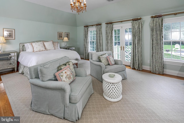 bedroom featuring french doors, baseboards, light wood finished floors, and an inviting chandelier