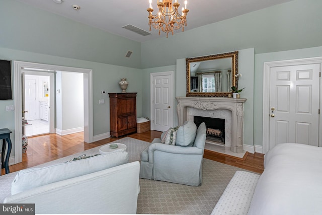 living room with lofted ceiling, a fireplace, visible vents, baseboards, and light wood-type flooring