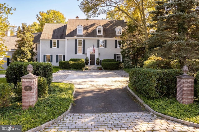 view of front facade featuring driveway and a chimney