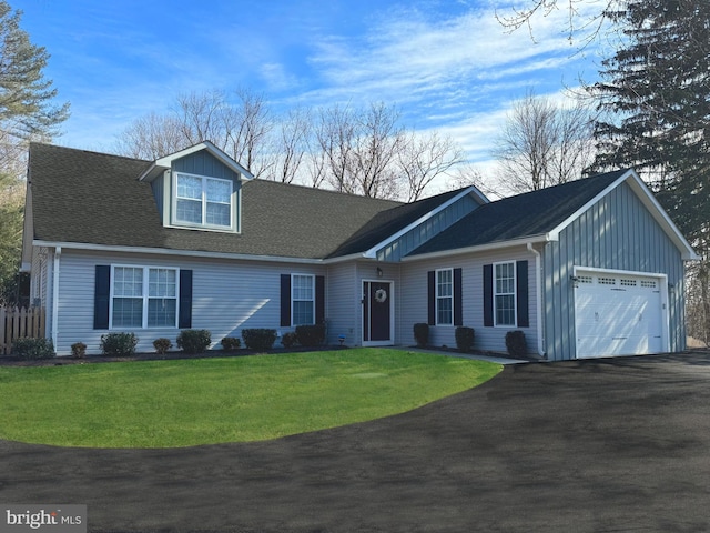 view of front of property featuring a garage, driveway, board and batten siding, and a front lawn