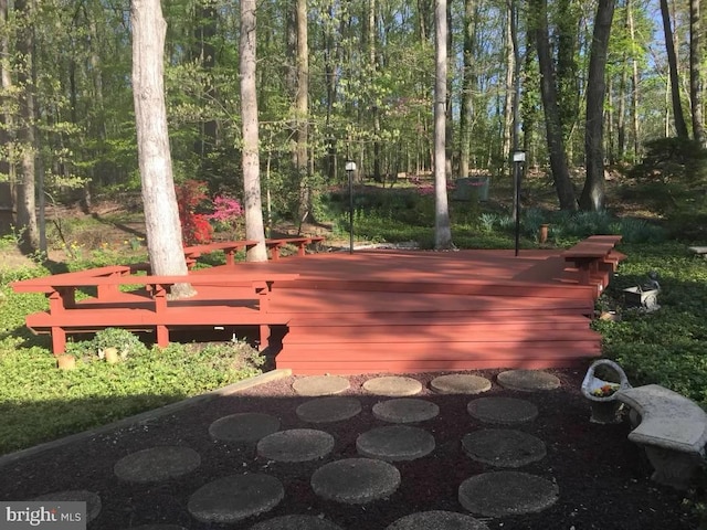 wooden terrace featuring a view of trees