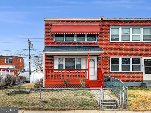 view of front of home featuring a fenced front yard, a gate, and brick siding