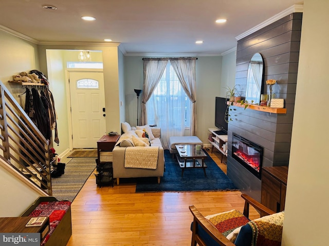 living room with hardwood / wood-style flooring, crown molding, recessed lighting, and a fireplace