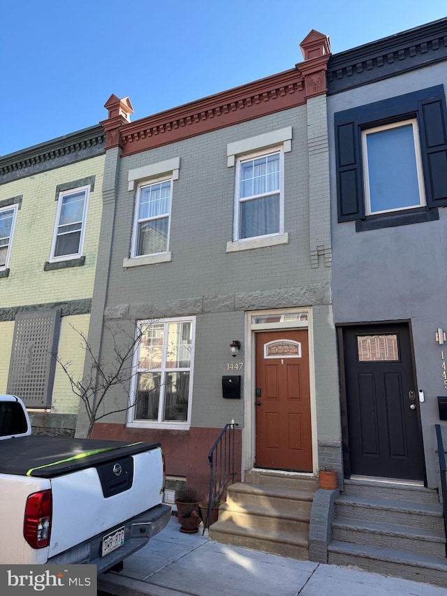 townhome / multi-family property featuring brick siding and entry steps