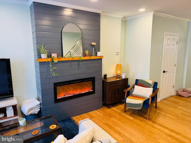 living room with recessed lighting, a fireplace, crown molding, and wood finished floors