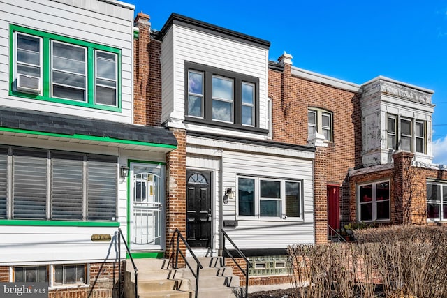 townhome / multi-family property featuring cooling unit and brick siding