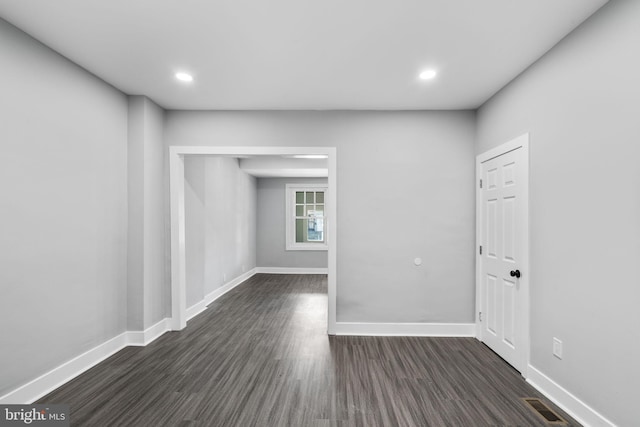 spare room with recessed lighting, visible vents, dark wood finished floors, and baseboards