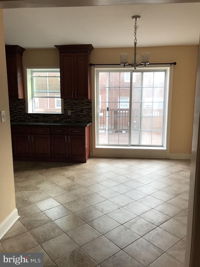 unfurnished dining area featuring plenty of natural light and baseboards