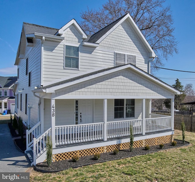 view of front of property featuring fence and covered porch