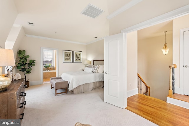 carpeted bedroom with ornamental molding, connected bathroom, visible vents, and baseboards