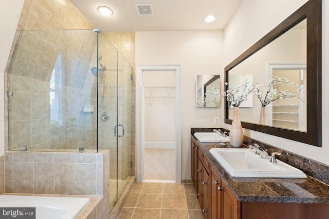 bathroom with a shower stall, a spacious closet, visible vents, and a sink