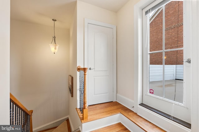 doorway with wood finished floors and baseboards