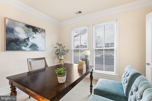 carpeted dining space featuring ornamental molding and visible vents