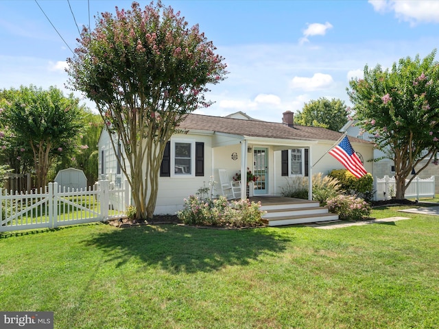 view of front of house with a front lawn, a chimney, and fence