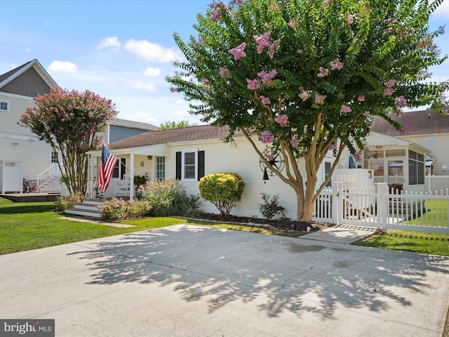 view of front facade featuring a front yard, a gate, and fence