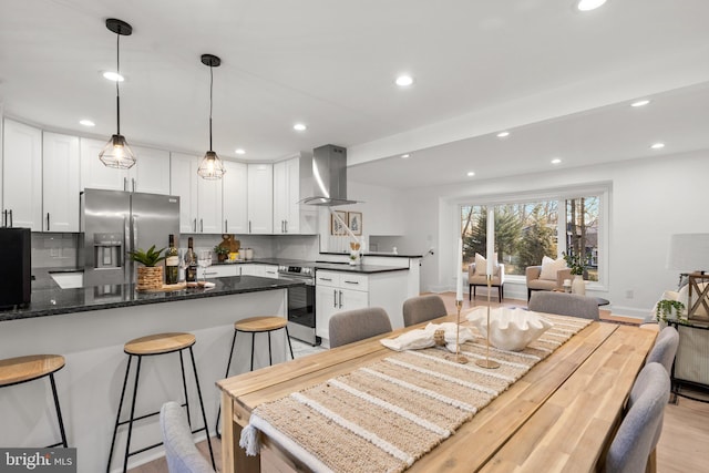 dining area featuring baseboards, light wood-type flooring, and recessed lighting