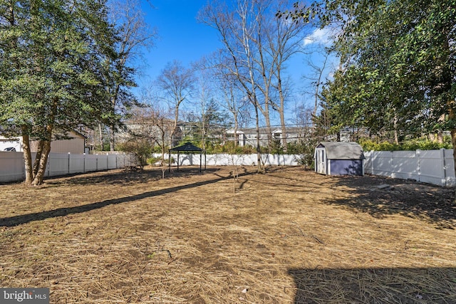 view of yard with an outbuilding, a fenced backyard, a gazebo, and a storage unit