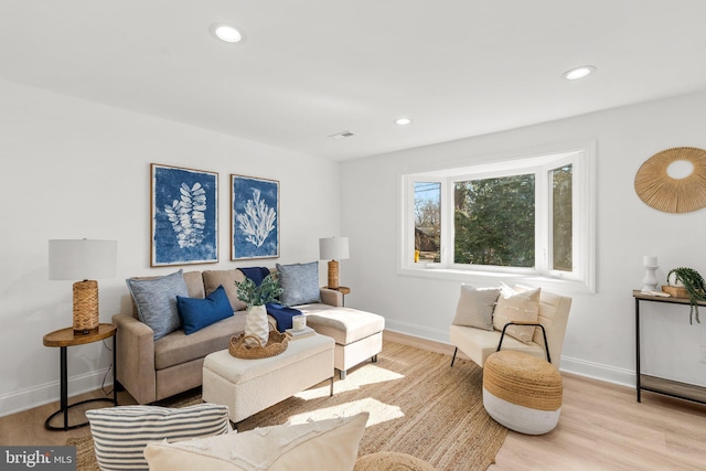 living area featuring baseboards, recessed lighting, and light wood-style floors