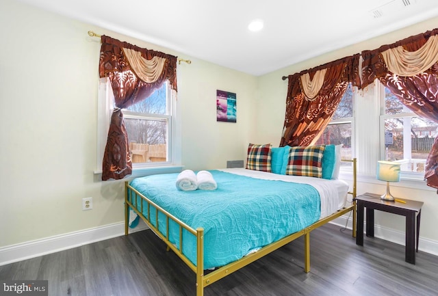 bedroom featuring visible vents, baseboards, and wood finished floors