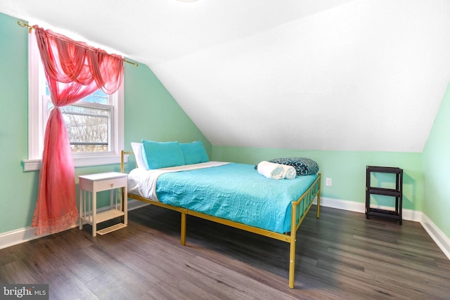 bedroom with dark wood-style floors, vaulted ceiling, and baseboards