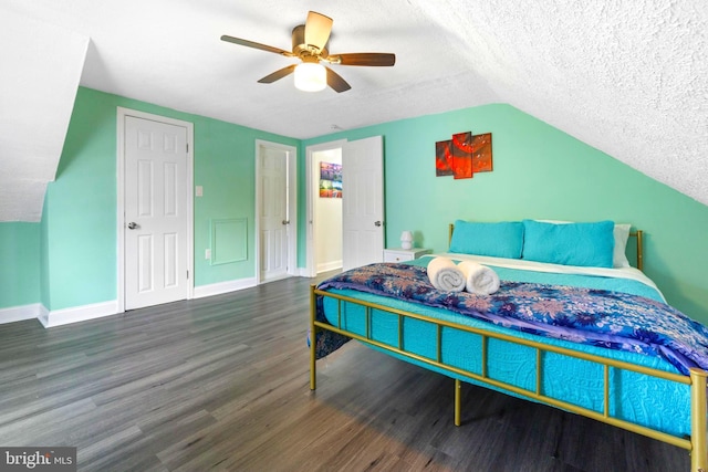 bedroom with a textured ceiling, ceiling fan, lofted ceiling, dark wood-type flooring, and baseboards