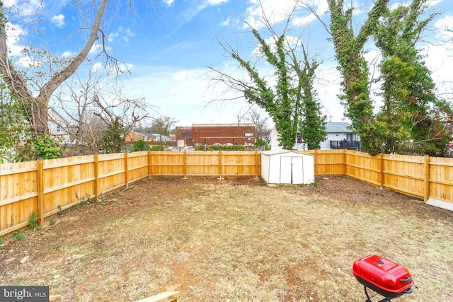 view of yard featuring an outbuilding, a fenced backyard, and a shed