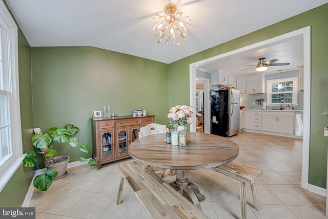 dining space with light tile patterned floors, baseboards, and ceiling fan with notable chandelier