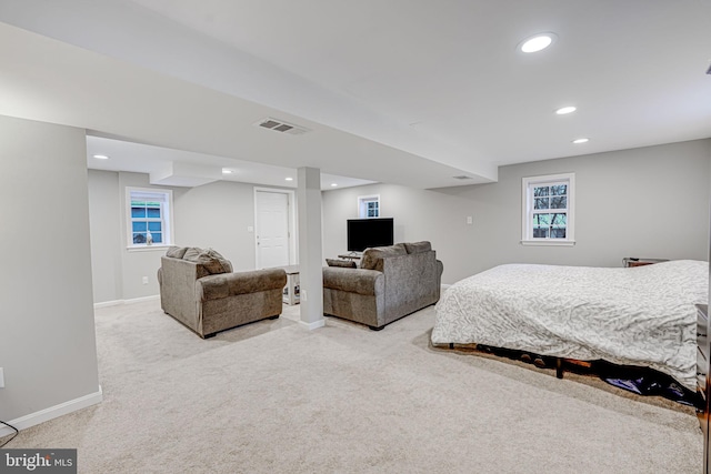 bedroom with recessed lighting, light colored carpet, visible vents, multiple windows, and baseboards