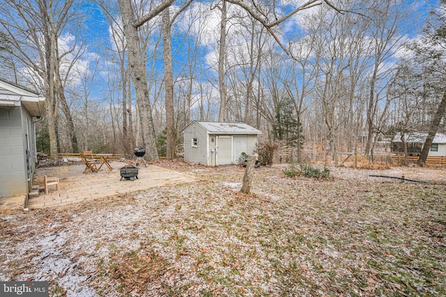 view of yard featuring a shed, an outdoor fire pit, a patio, and an outdoor structure