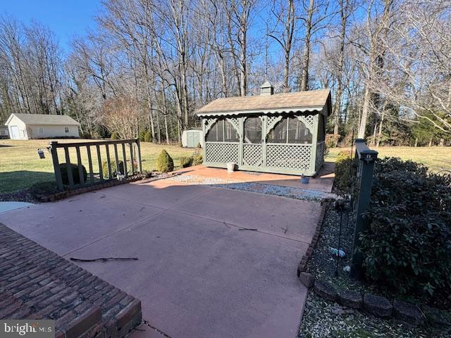 view of patio with a sunroom and an outdoor structure