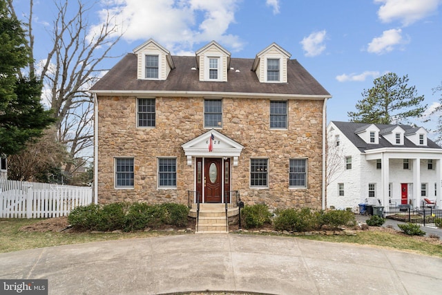 colonial-style house featuring fence