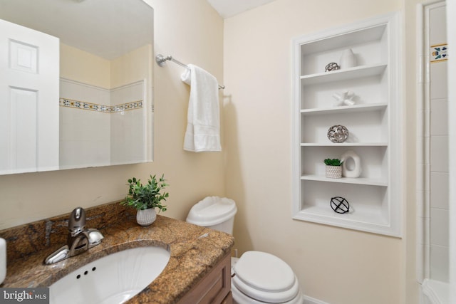 bathroom with built in features, vanity, and toilet