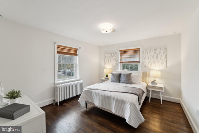 bedroom featuring radiator, multiple windows, baseboards, and hardwood / wood-style flooring