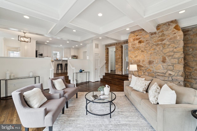 living area featuring coffered ceiling, wood finished floors, visible vents, stairway, and beam ceiling