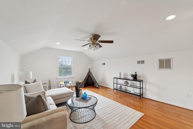 living area featuring light wood-type flooring, ceiling fan, visible vents, and lofted ceiling