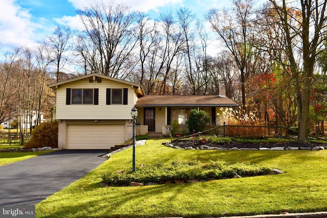 split level home with aphalt driveway, an attached garage, brick siding, a front lawn, and a chimney