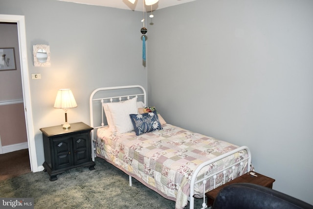 bedroom featuring dark carpet and baseboards