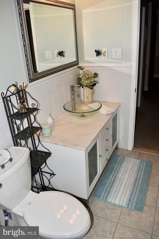 bathroom with wainscoting, vanity, toilet, and tile patterned floors