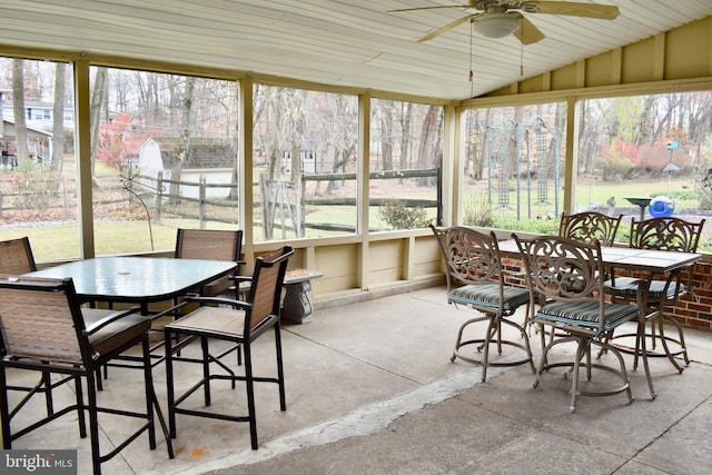 sunroom featuring lofted ceiling, a wealth of natural light, and a ceiling fan