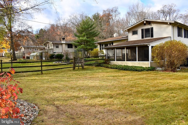 view of yard featuring a sunroom and fence