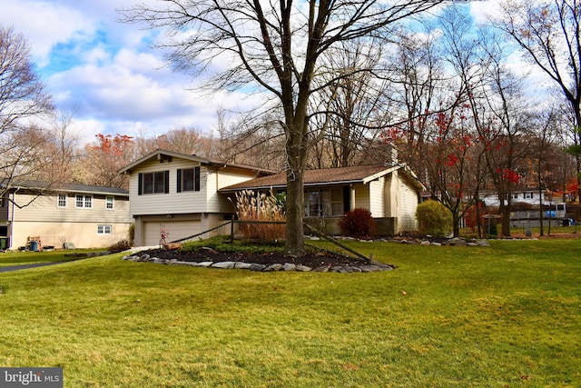 split level home featuring a garage and a front lawn