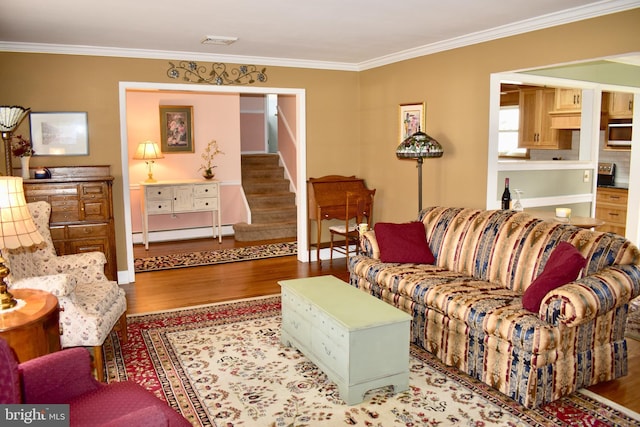 living room with ornamental molding, light wood finished floors, a baseboard radiator, and stairs