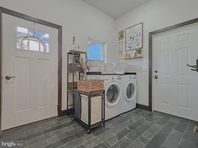 washroom featuring laundry area, separate washer and dryer, and baseboards