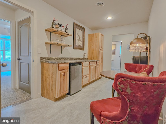 interior space featuring visible vents, dishwasher, light colored carpet, light countertops, and light brown cabinets