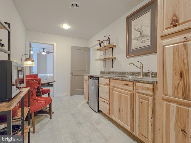 kitchen with visible vents, a sink, light brown cabinetry, open shelves, and stainless steel dishwasher